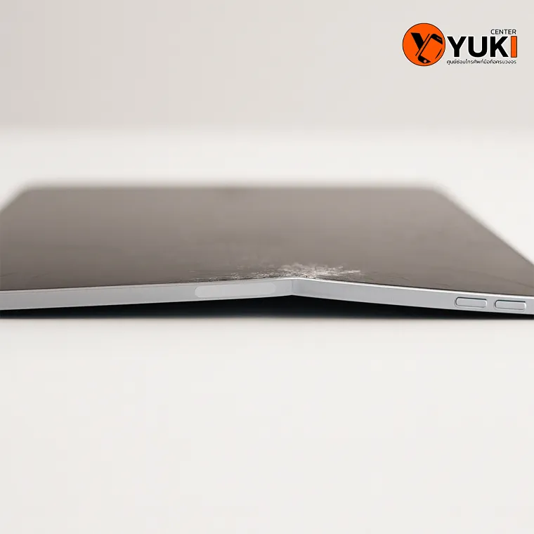 iPad งอ วางบนพื้นเรียบ เห็นเครื่องบิดงอชัดเจน ปัญหาที่เกิดจากแรงกดทับหรือการใช้งานผิดวิธี ต้องซ่อมหรือเปลี่ยน Housing