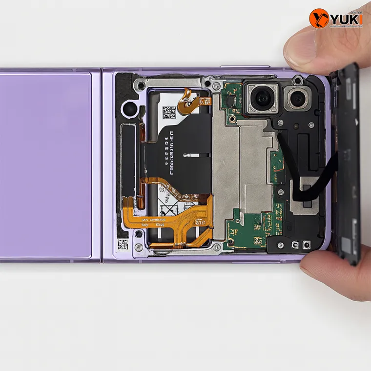 ภาพช่างกำลังเปิดฝาหลัง Samsung Z Flip 6 เพื่อซ่อมบำรุงและตรวจสอบแบตเตอรี่ โดยร้านซ่อมมือถือ Yuki Center