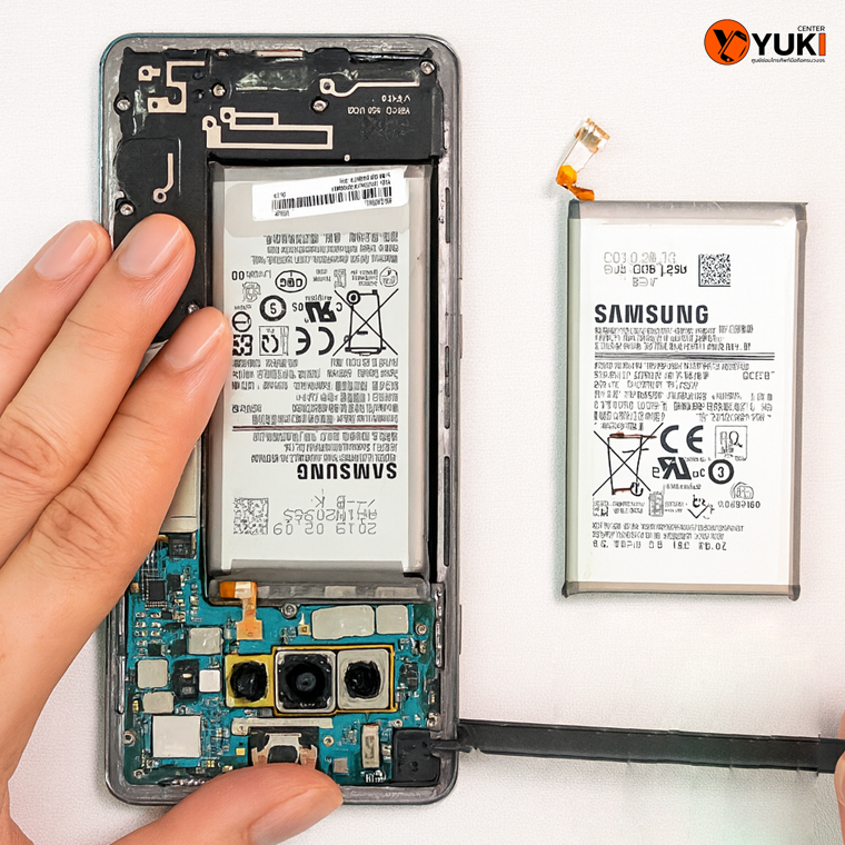 มือถือ Samsung เปิดเครื่องซ่อม วางแบตเตอรี่เก่าและแบตใหม่เปรียบเทียบกันบนโต๊ะซ่อม