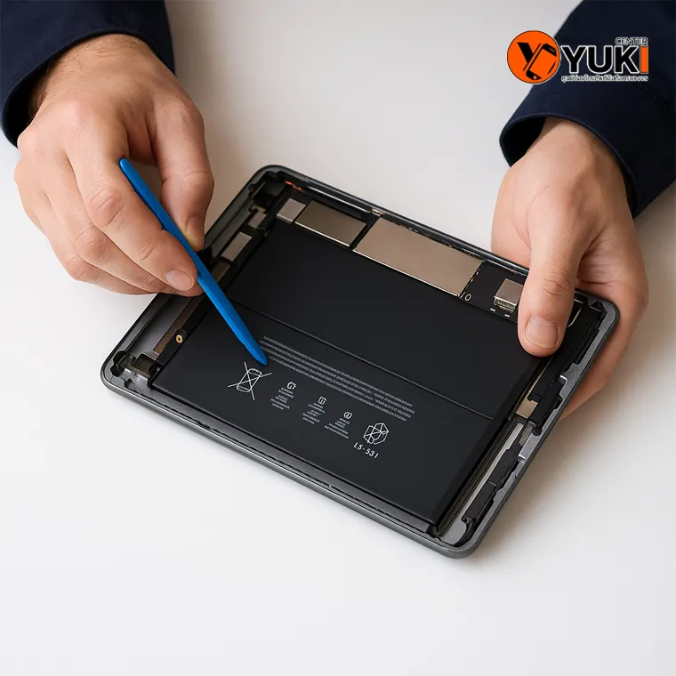ช่างกำลังใช้เครื่องมือเฉพาะในการเปลี่ยนแบตเตอรี่ iPad อย่างปลอดภัย ที่ร้าน Yuki Center