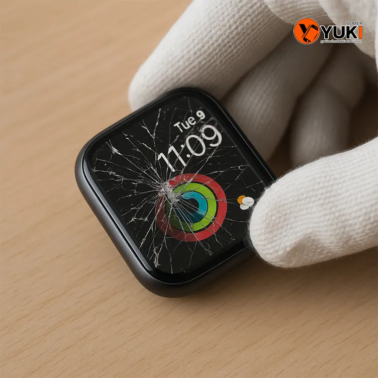 Apple Watch หน้าจอแตกเป็นรอยร้าวหลายจุด ช่างสวมถุงมือกำลังตรวจสอบอาการบนโต๊ะไม้ เพื่อประเมินการซ่อมและเปลี่ยนกระจกหรือจอภาพ