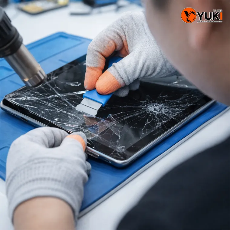 ช่างกำลังลอกกระจก iPad หน้าจอแตกด้วยอุปกรณ์เฉพาะ ในห้องซ่อมมาตรฐาน รังสิต